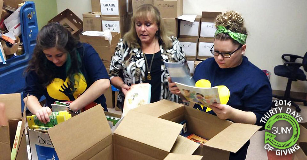 Onondaga Community College female students with United Way VP sorting books during OCC Day of Service.