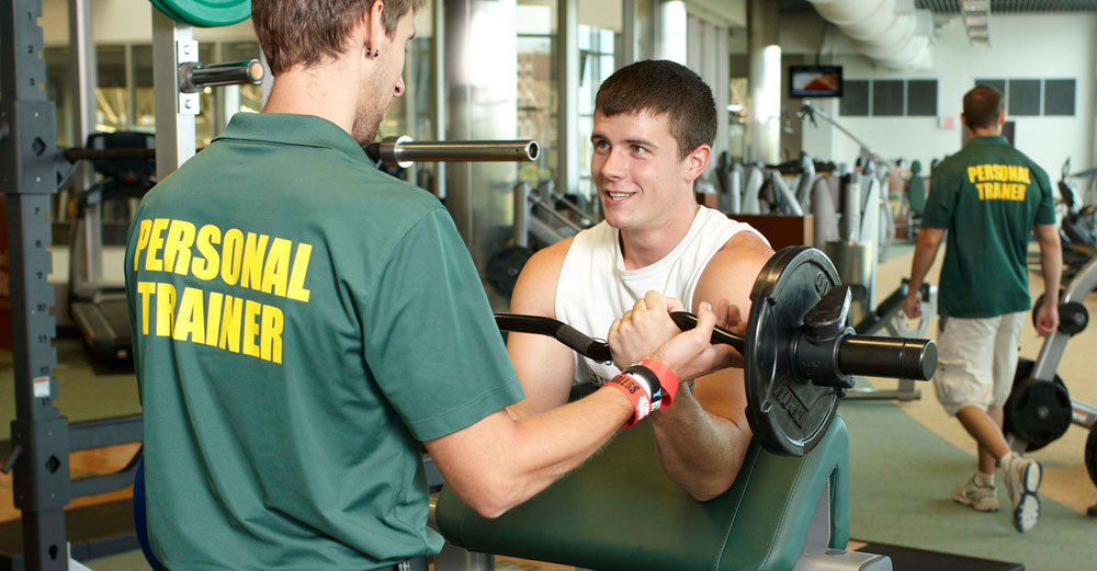 Brockport student works out with trainer in school gym.