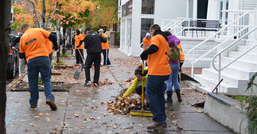 Students at SUNY Buffalo State do community cleanup outside.