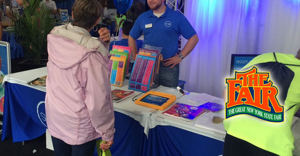 SUNY representative speaks to visitors at the 2014 NY State Fair.