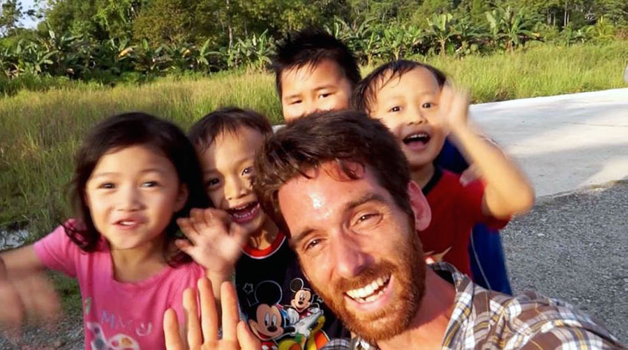 Paul Stoutenburgh in Malaysia with children while filming for the Borneo Project. 