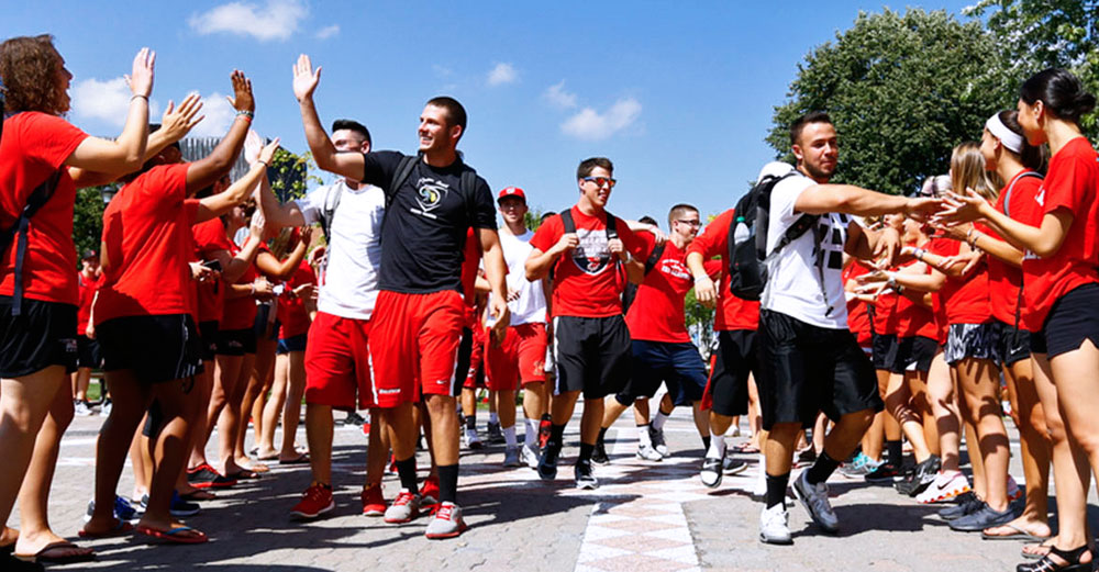 Students walking through high-five line on Oneonta Red Day