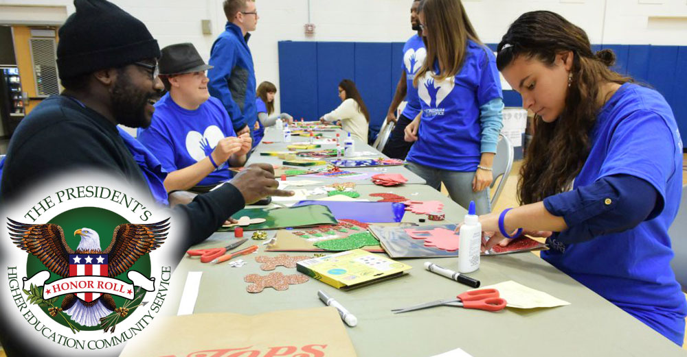 Students at Onondaga Community College design crafts at a table in the gym. 