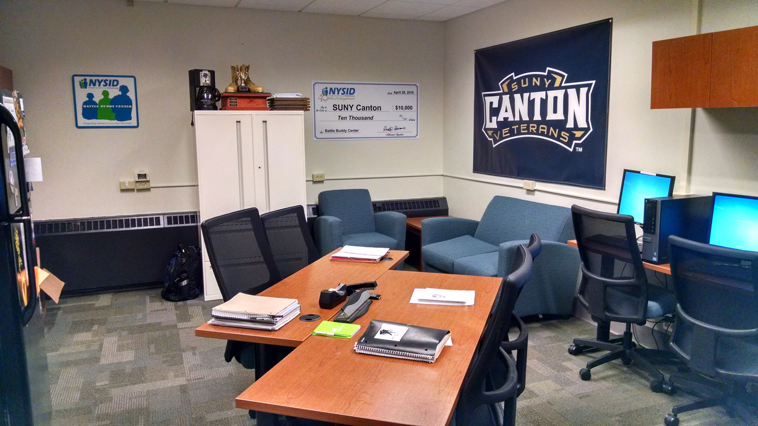 Interior of the SUNY Canton Battle Buddy Center, with couches, computers, workspaces, lockers.