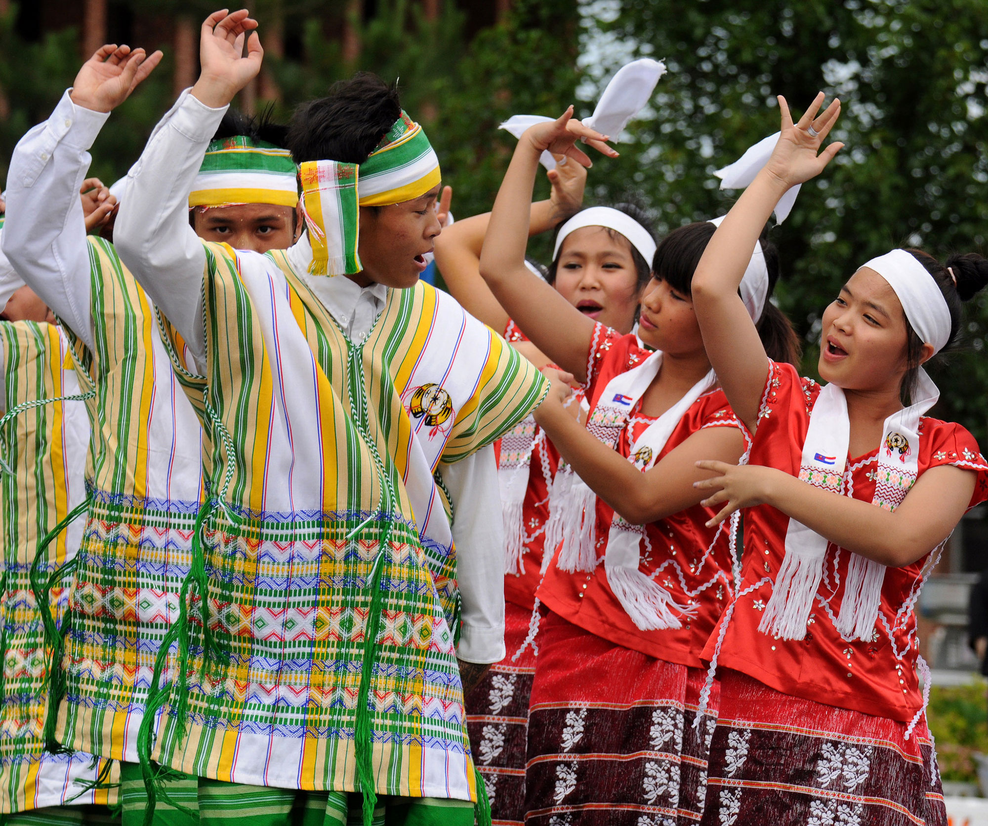 Refugee dancers outside in traditional outfits. 