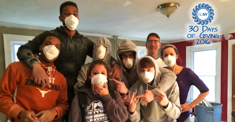 Students from Cayuga Community College pose with their dust masks while building a house for Habitat for Humanity.