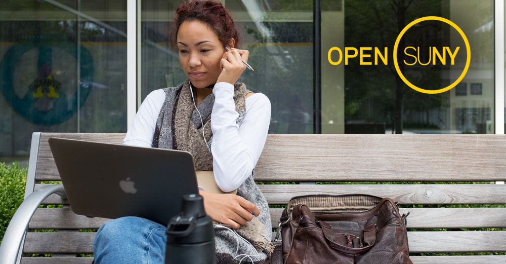 Girl outside on bench working on laptop with Open SUNY logo