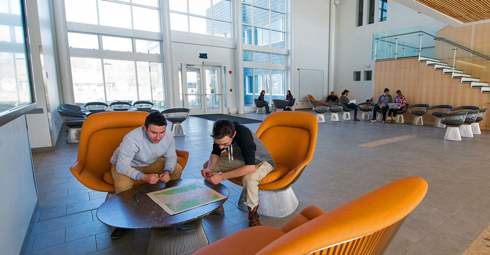 New SUNY New Paltz Science Hall lobby with students in yellow lounge chairs