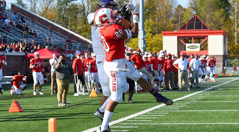 A Cortland football defensive back intercepts a pass against Alfred University