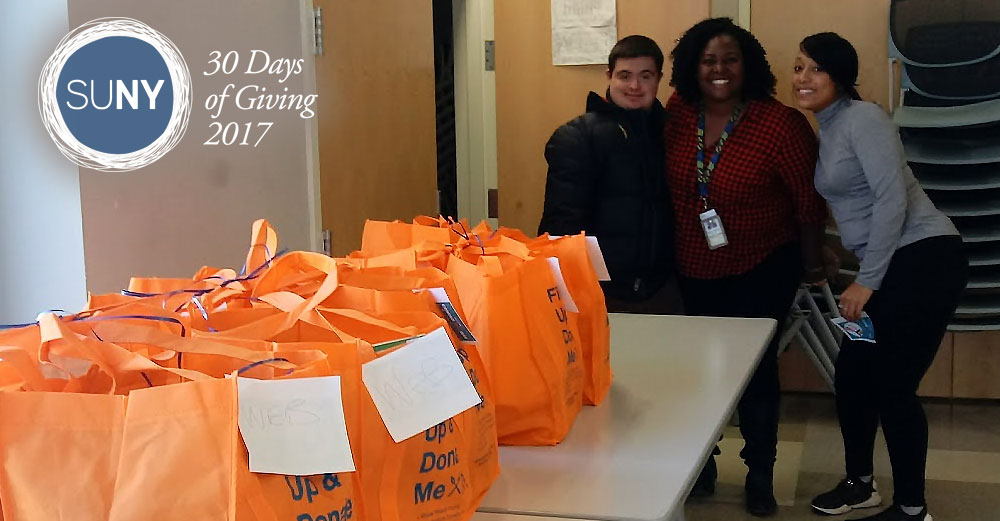 Westchester Community College students stand behind a table of orange bags filled with food donations.