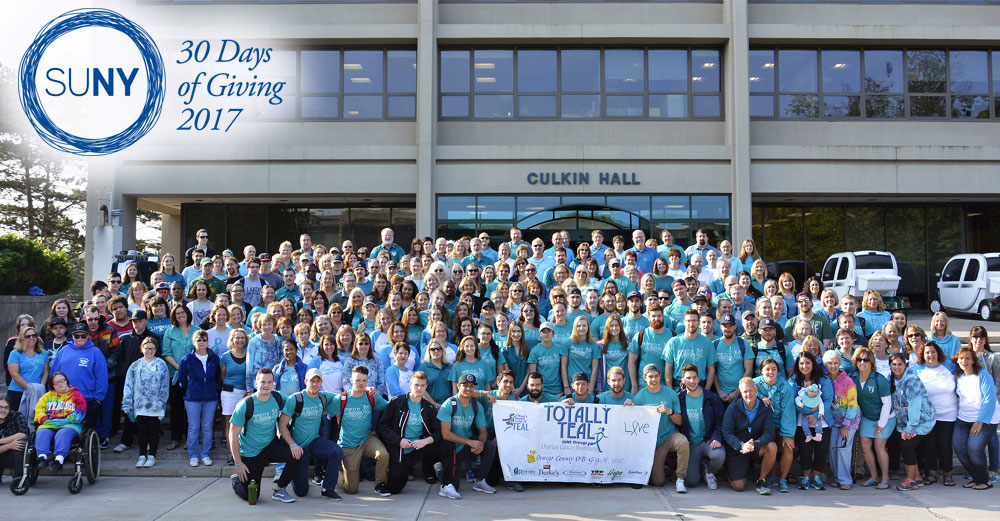 Participants pose in front of Culkin Hall at SUNY Oswego on Teal Day.