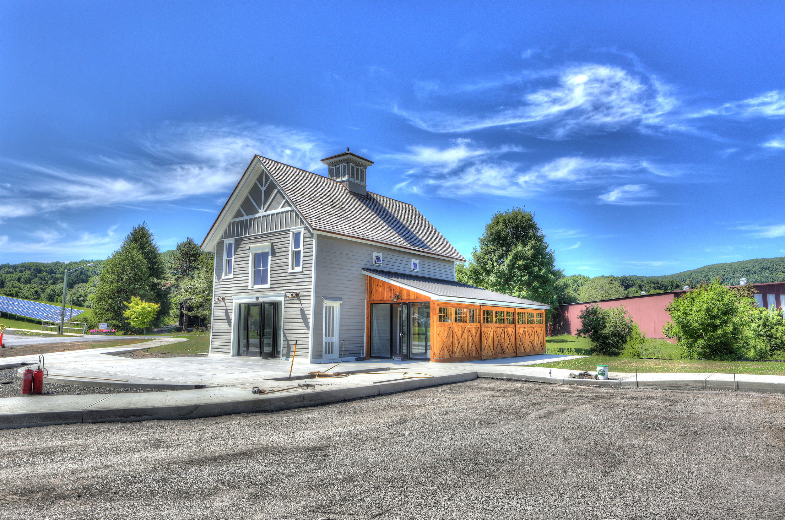 Coblsekill cafe and general store exterior with solar panels on the grass to the left side.