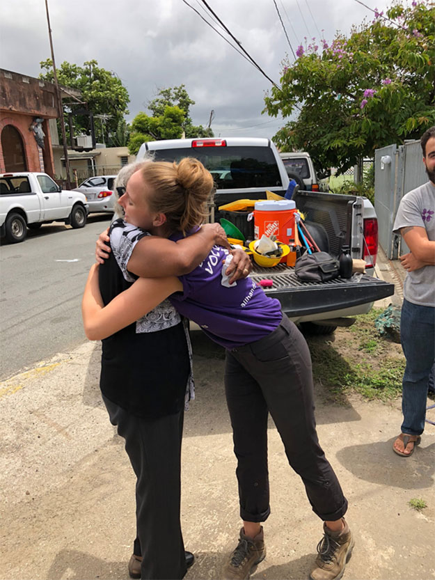 A SUNY student hugs a local resident after completing work for the day.