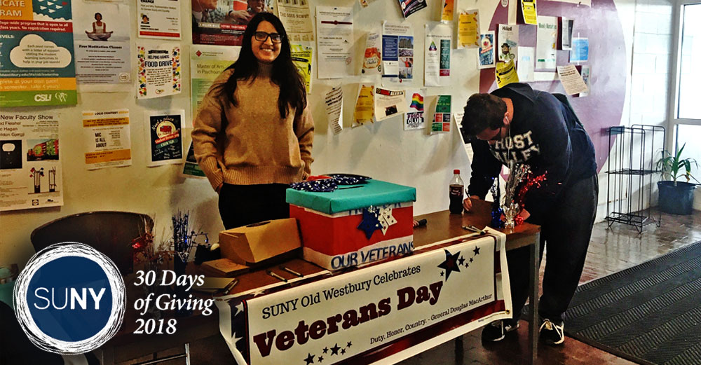 SUNY Old Westbury students stand at a table with letters offering letters to be written to send to veterans.