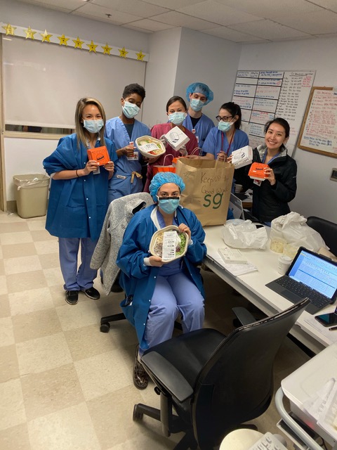 Medical frontline workers show off their packaged meals inside a hospital break room. 