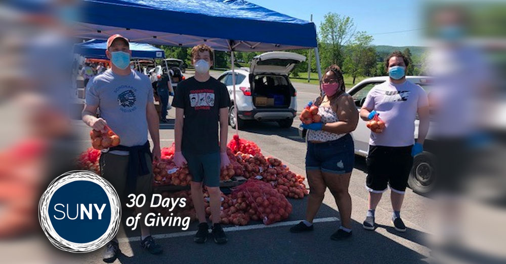 SUNY Cobleskill students stand in parking lot during mobile food drive.