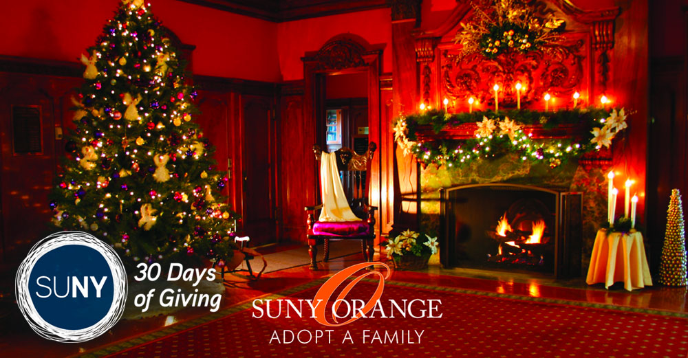 Formal room with christmas tree, fire in fireplace, and decorations hung with SUNY Orange Adopot A Family logo