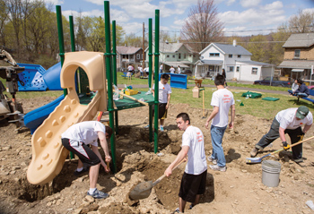 Binghamton School of Management students with the Pricewaterhouse Coopers Scholars cleaning up a playground's land