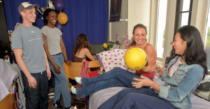 University at Albany students laugh in a dorm room.
