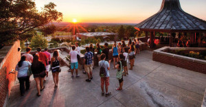 students gathered outdoors at Geneseo during sunset