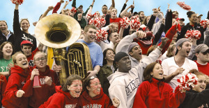 Oneonta sports fans cheer from bleachers with school band.
