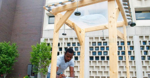 Deshawn Henry of the Univeristy at Buffalo uses his device made of wood, plastic sheeting and water, to disinfect water.