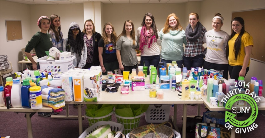 Bcokport students stand behind table of home goods donations.