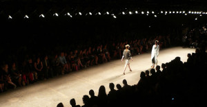 Fashion show runway with 2 models walking.