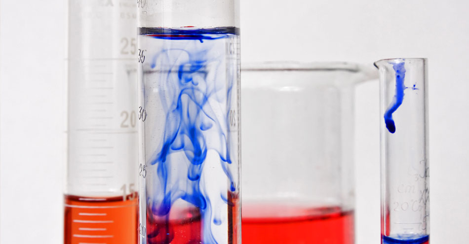 beakers with red and blue liquids and gases in them.
