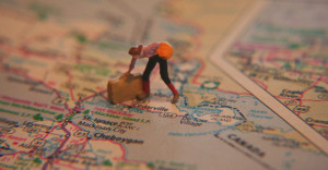 road map with little rubber person figurine with suitcase.