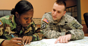 Male and female ROTC students at Brockport do homework together at a table.