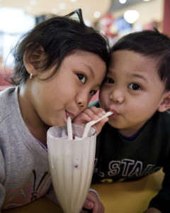 Children sharing a milkshake