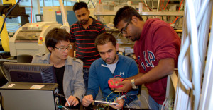 Workers at Advanced Materials Analytics of Binghamton University look over electronics.