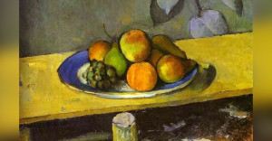 Old painting of fruit on a plate on a yellow table.
