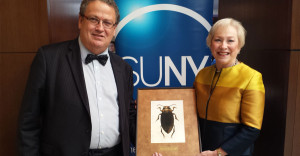 SUNY ESF President Quentin Wheeler and SUNY Chancellor Nancy ZImpher stand with a picture of the new beetle named after her.