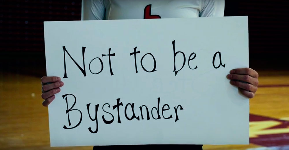 Oneonta student athlete with sign that says "Not to be a bystander"