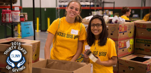 2 female Brockport students pack boxes of donations during Saturday of Service