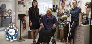 A military veteran sits in wheelchair wearing an outfit designed by FIT students.