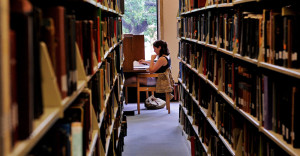 Girl studying at table in library.