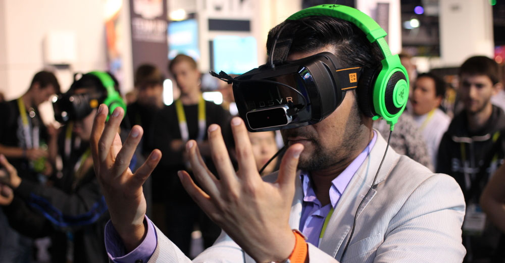 Person wearing virtual reality goggles with hands in front of face.