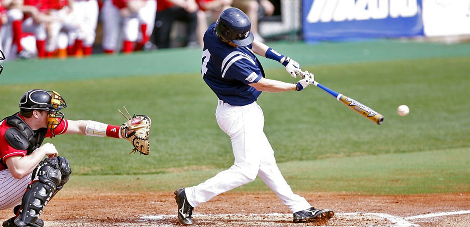 Batter swings to hit a ball in baseball game.