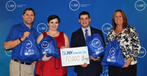 Joseph Storch, SUNYSA Vice President Bridget Doyle, SUNYSA President Marc Cohen, and SUNY Oswego's Lisa Evaneski stand with the 10,000th bag filled for SUNY's Got Your Back.