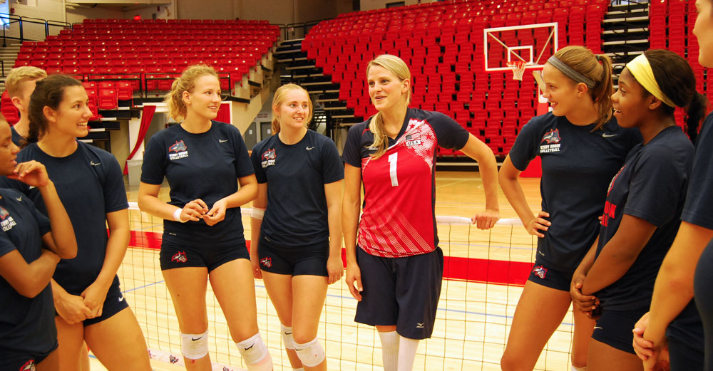Lora Webster talks to the Stony Brook womens volleyball team on the court.