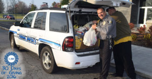 FMCC officer takes food donations out of SUV squad car.