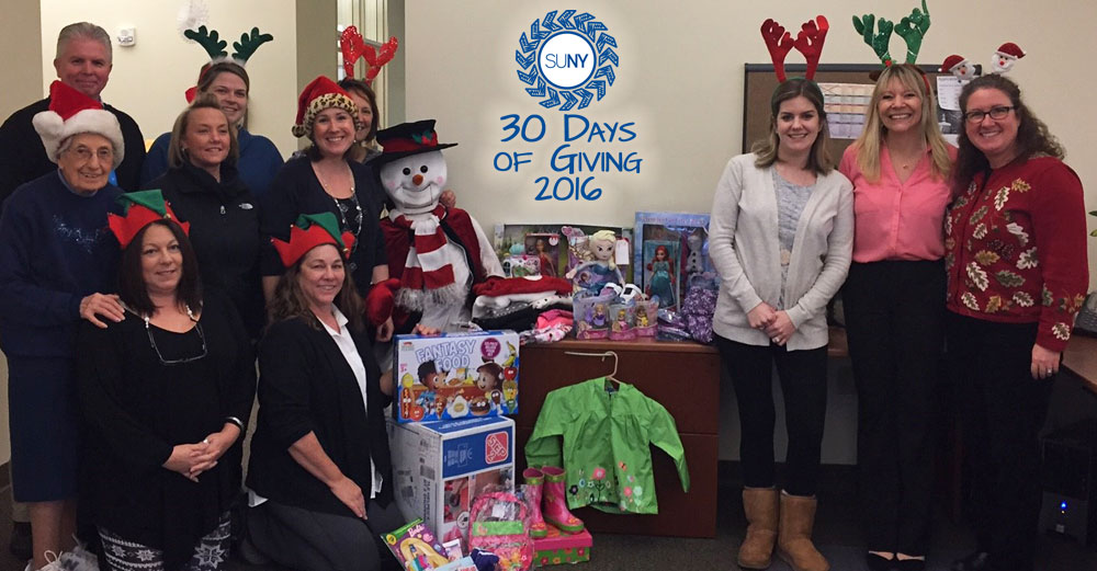 Empire State College office of admissions staff pose with gifts gathered for Empty Stockings project.
