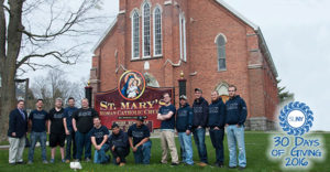 The SUNY Canton brothers of Alpha Omega Chi fraternity stand in front of St Marys Church after clean up project.
