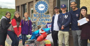 30 Days of Giving logo over group standing outside in front of gifts.