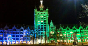 SUNY Plaza shines in blue and green lights at night.