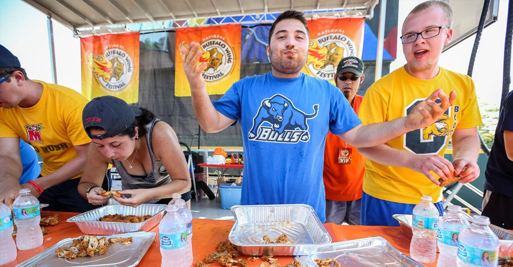 Student from UBuffalo raises his hands after the College Wing Eating contest at Buffalo Wing Fest.