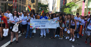 SUNY students and staff pose with a banner that states "celebrating diversity and inclusion since 1948" at the 2017 NYC Pride Parade.